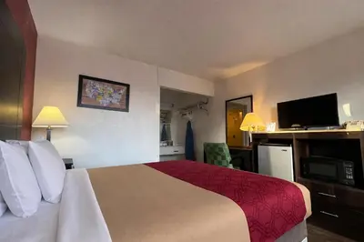 a hotel room with a bed and a flat screen tv at Econo Lodge Carlisle in Carlisle
