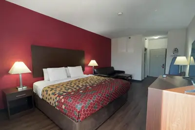 a bedroom with a bed and a red wall at Econo Lodge Carlisle in Carlisle