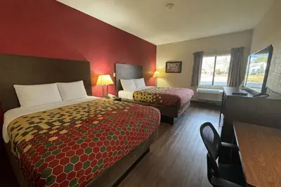 a hotel room with two beds and a desk at Econo Lodge Carlisle in Carlisle