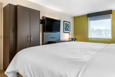 a bedroom with a white bed and a flat screen tv at Holiday Inn Express Jonestown Ft Indiantown Gap by IHG in Jonestown
