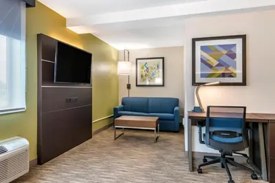 a hotel room with a desk and a blue chair at Holiday Inn Express Jonestown Ft Indiantown Gap by IHG in Jonestown