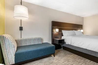 a hotel room with a bed and a chair at Holiday Inn Express Jonestown Ft Indiantown Gap by IHG in Jonestown