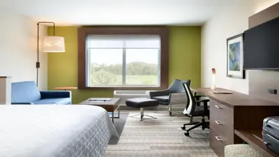 a hotel room with a bed and a desk and chairs at Holiday Inn Express Jonestown Ft Indiantown Gap by IHG in Jonestown
