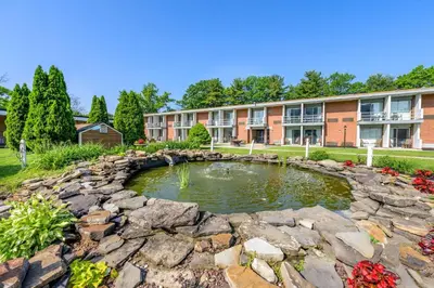 a garden with a pond in front of a building at Inn at Lebanon - Hershey & Manheim area in Lebanon