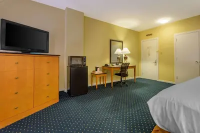 a hotel room with a bed and a flat screen tv at Inn at Lebanon - Hershey & Manheim area in Lebanon