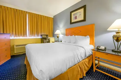 a hotel room with a large bed and a telephone at Inn at Lebanon - Hershey & Manheim area in Lebanon