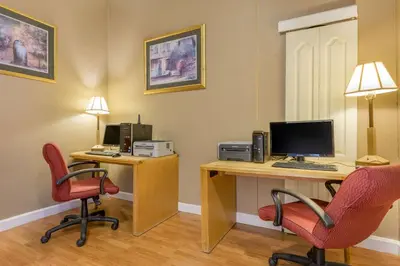 a room with a desk with a computer and two chairs at Inn at Lebanon - Hershey & Manheim area in Lebanon