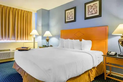 a hotel room with a large bed with white sheets at Inn at Lebanon - Hershey & Manheim area in Lebanon