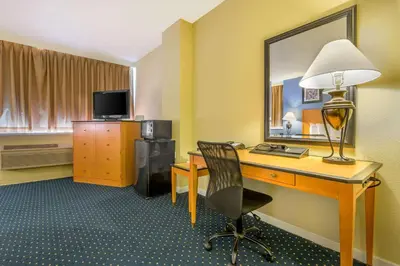 a hotel room with a desk and a lamp at Inn at Lebanon - Hershey & Manheim area in Lebanon