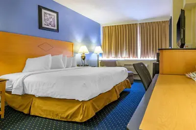 a hotel room with a large bed and a television at Inn at Lebanon - Hershey & Manheim area in Lebanon