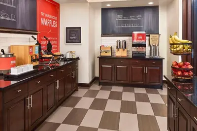 a kitchen with wooden cabinets and a checkered floor at Hampton Inn & Suites Hershey Near the Park in Hummelstown