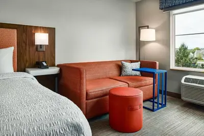 a hotel room with a bed and a chair at Hampton Inn & Suites Hershey Near the Park in Hummelstown