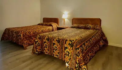 a hotel room with two beds and a table with a lamp at Budget Inn New Cumberland-Harrisburg-Hershey-York in New Cumberland