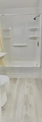 a white bathroom with a toilet and a floor at Budget Inn New Cumberland-Harrisburg-Hershey-York in New Cumberland