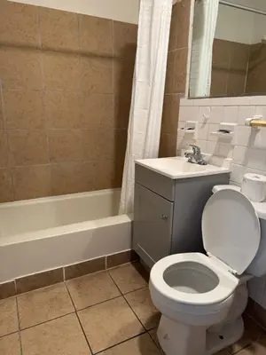 a bathroom with a toilet and a sink and a tub at Budget Inn New Cumberland-Harrisburg-Hershey-York in New Cumberland