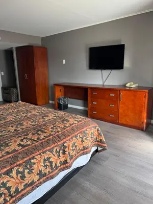 a hotel room with a bed and a flat screen tv at Budget Inn New Cumberland-Harrisburg-Hershey-York in New Cumberland
