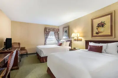 a hotel room with two beds and a television at Traditions Hotel & Spa Johnson City - Binghamton, an Ascend Collection Hotel in Johnson City