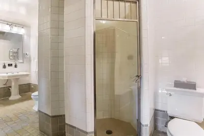a bathroom with a shower and a toilet and a sink at Traditions Hotel & Spa Johnson City - Binghamton, an Ascend Collection Hotel in Johnson City