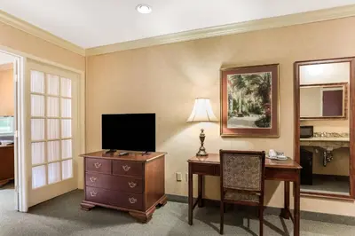 a hotel room with a desk and a television at Traditions Hotel & Spa Johnson City - Binghamton, an Ascend Collection Hotel in Johnson City