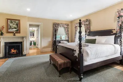 a bedroom with a large bed and a fireplace at Traditions Hotel & Spa Johnson City - Binghamton, an Ascend Collection Hotel in Johnson City