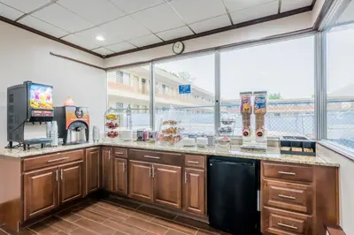 a large kitchen with wooden cabinets and a large window at Red Carpet Inn Lancaster in Lancaster