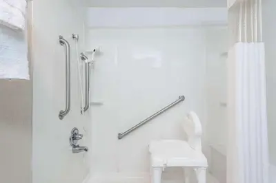 a bathroom with a shower and a white toilet at Red Carpet Inn Lancaster in Lancaster