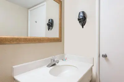 a bathroom with a sink and a mirror at Red Carpet Inn Lancaster in Lancaster