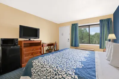 a hotel room with a bed and a flat screen tv at Days Inn by Wyndham Middletown in New Hampton