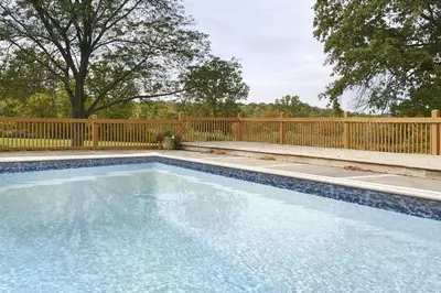 a swimming pool in front of a wooden fence at Days Inn by Wyndham Middletown in New Hampton