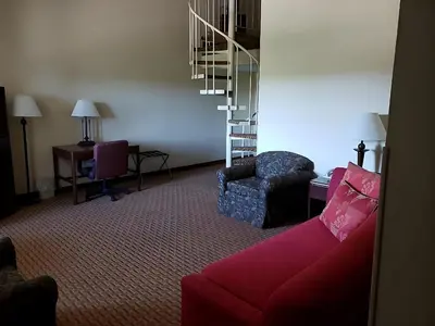 a living room with a red couch and a chair at Chateau Resort & Conference Center in Tannersville