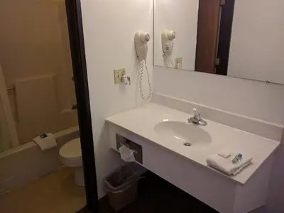a bathroom with a sink and a phone on the wall at Value Inn Harrisburg-York in Valley Green