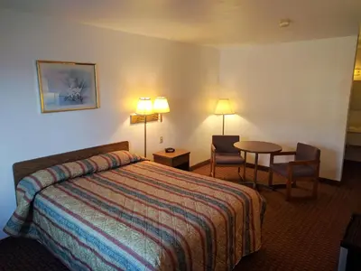 a hotel room with a bed and a table and chairs at Value Inn Harrisburg-York in Valley Green