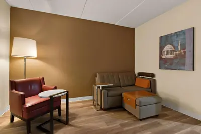 a waiting room with a couch and a chair at Ramada by Wyndham Harrisburg/Hershey Area in Harrisburg