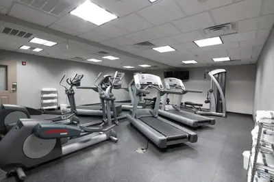 a gym with treadmills and elliptical machines at Country Inn & Suites by Radisson, Harrisburg - Hershey West, PA in Harrisburg