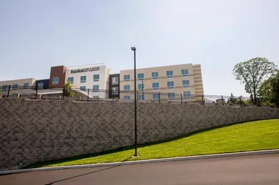 a building with a stone wall next to a street at Fairfield Inn & Suites by Marriott Philadelphia Broomall/Newtown Square in Broomall