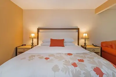 a bedroom with a bed with a red pillow on it at Hawthorn Suites by Wyndham Allentown-Fogelsville in Fogelsville