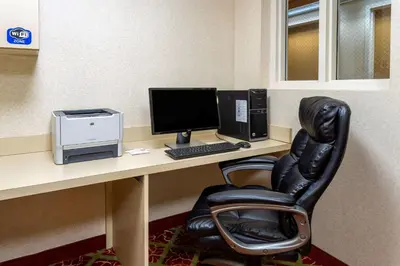 a desk with a computer monitor and a chair at Hawthorn Suites by Wyndham Allentown-Fogelsville in Fogelsville
