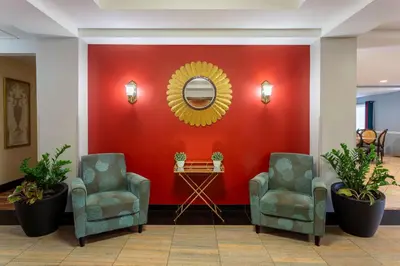 two chairs and a mirror on a red wall at Hawthorn Suites by Wyndham Allentown-Fogelsville in Fogelsville