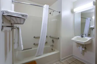 a white bathroom with a shower and a sink at Hawthorn Suites by Wyndham Allentown-Fogelsville in Fogelsville