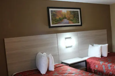 a hotel room with two beds and a picture on the wall at Travel Inn & Suites Flemington in Flemington