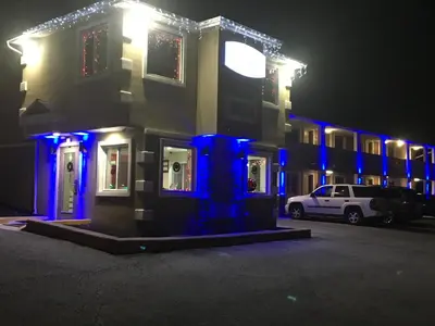 a house with blue lights on it at night at Travel Inn & Suites Flemington in Flemington