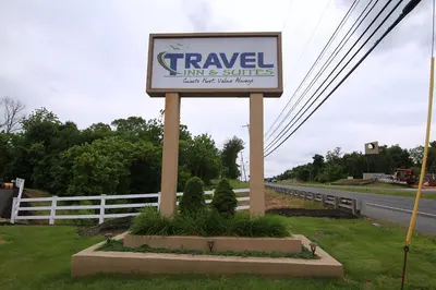 a sign for a travel inn and suites on the side of a road at Travel Inn & Suites Flemington in Flemington