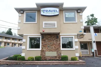 a building with a clock on the side of it at Travel Inn & Suites Flemington in Flemington