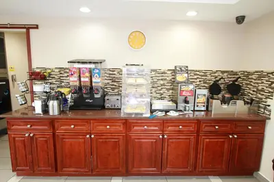 a counter with wooden cabinets in a room at Travel Inn & Suites Flemington in Flemington