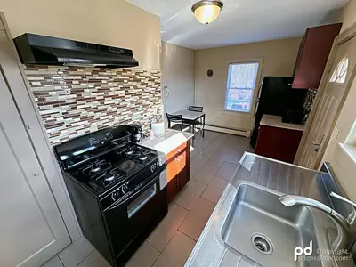 a kitchen with a stove and a sink at Travel Inn & Suites Flemington in Flemington