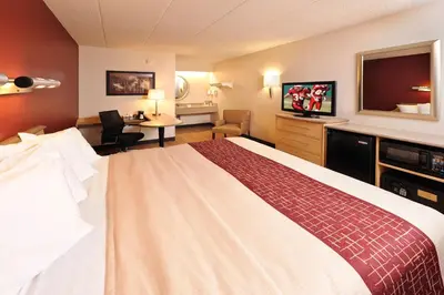 a hotel room with a large bed and a desk at Red Roof Inn Harrisburg - Hershey in Harrisburg