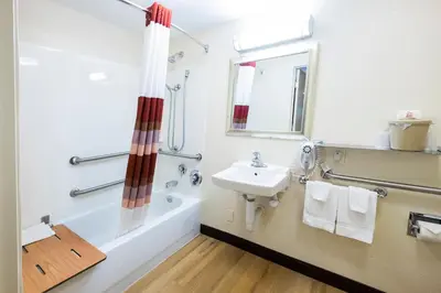 a bathroom with a sink and a tub and a toilet and a mirror at Red Roof Inn Harrisburg - Hershey in Harrisburg