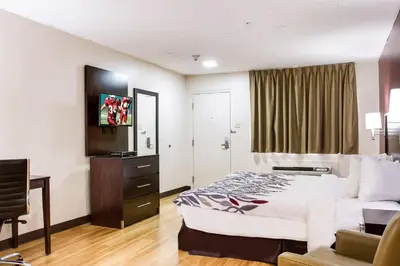 a hotel room with a bed and a chair at Red Roof Inn York Downtown in York