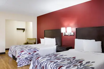 a hotel room with two beds and a red wall at Red Roof Inn York Downtown in York