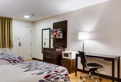 a hotel room with a bed and a desk and a chair at Red Roof Inn York Downtown in York